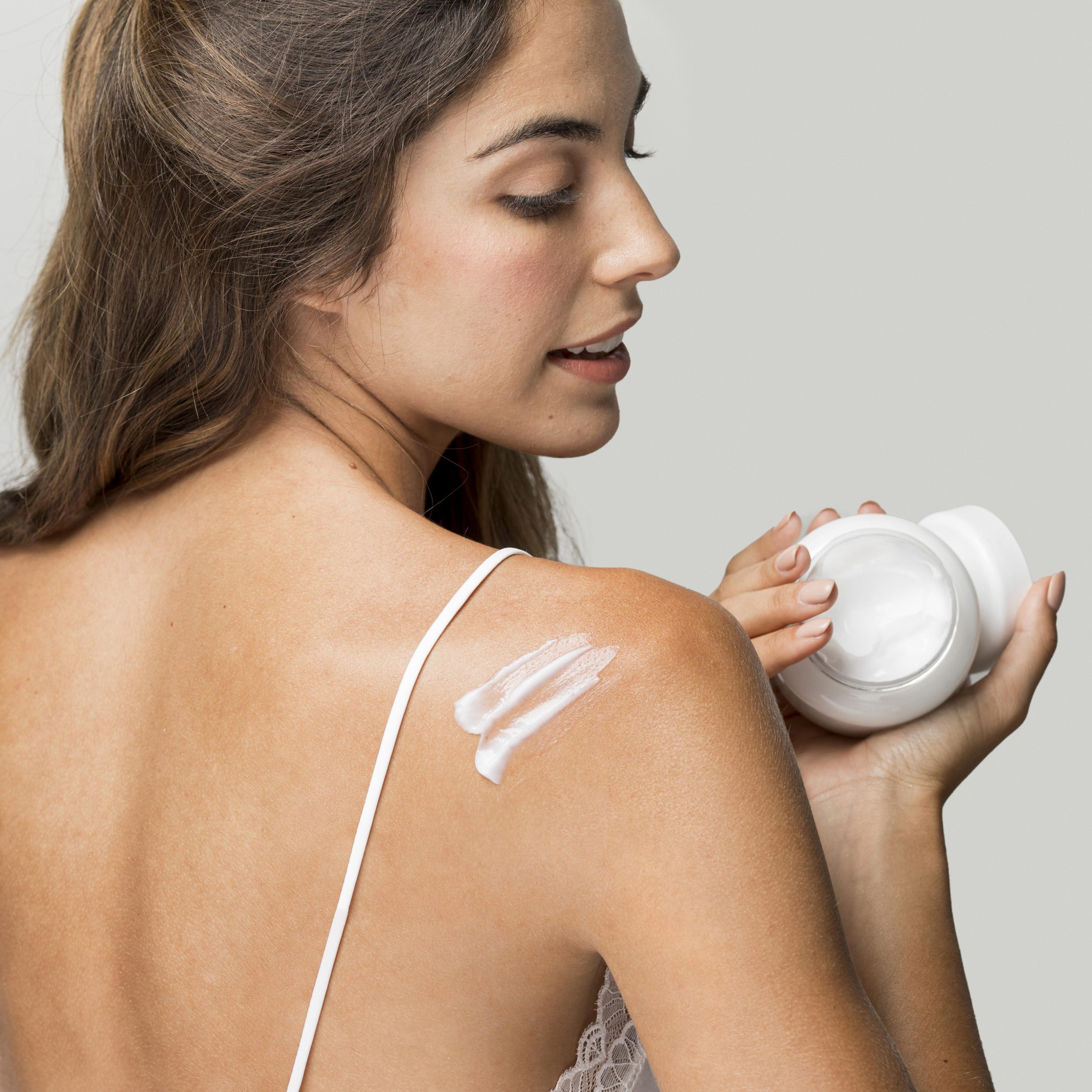 woman-applying-cream-her-back